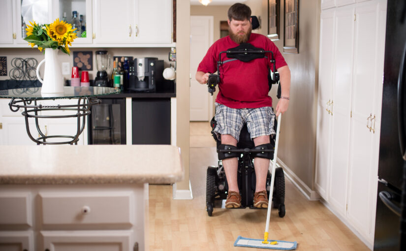Man in standing chair cleaning kitchen